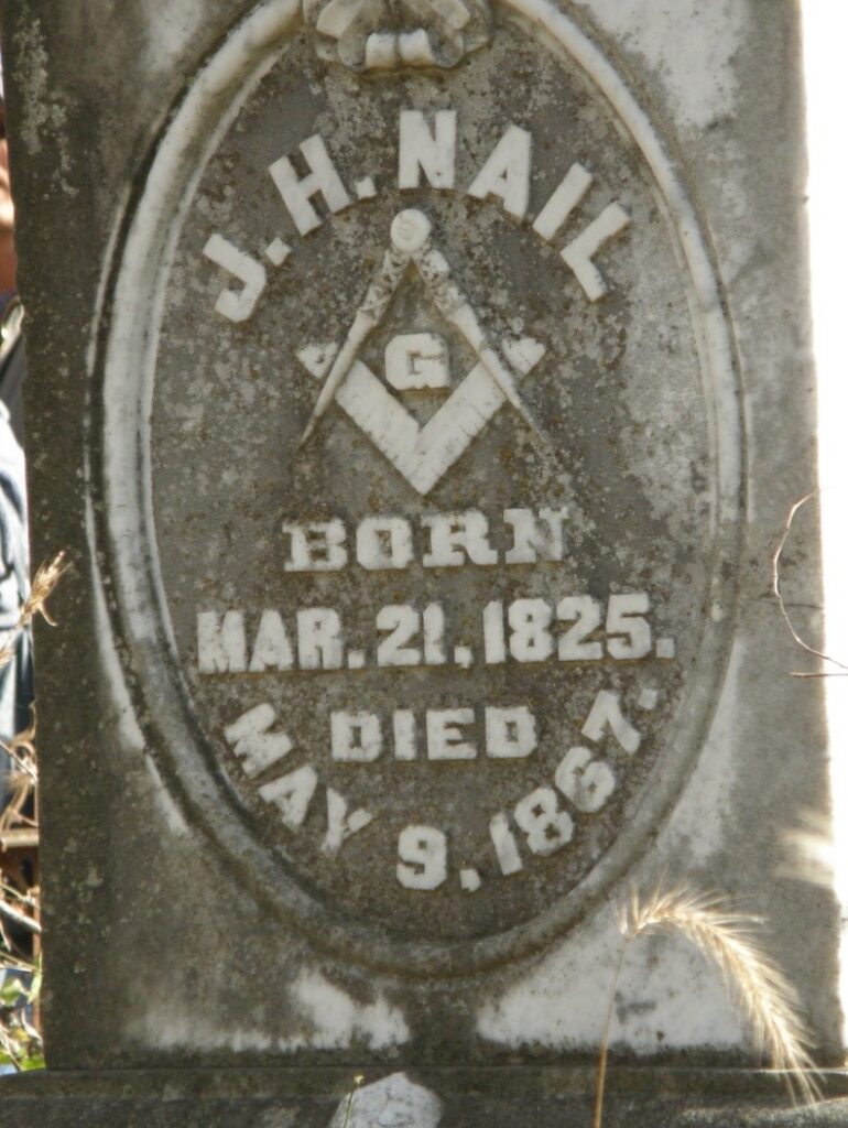 Tombstone for J.H. Nail bearing a masonic compass and square symbol. Born: Mar 21, 1825. Died May 9, 1867.
